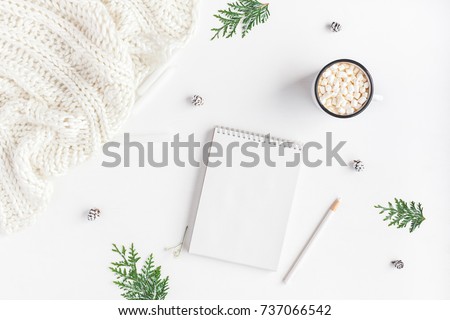 Christmas composition. Hot chocolate, knitted blanket, notebook, thuja branches on white background. Christmas, winter, new year concept. Flat lay, top view, copy space