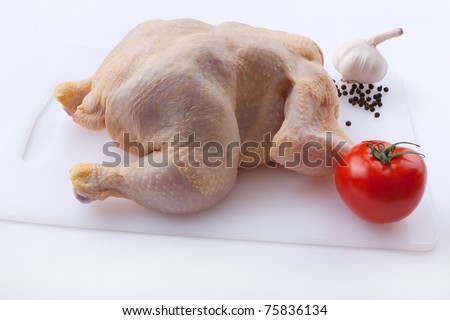 Raw chicken with tomato and garlic