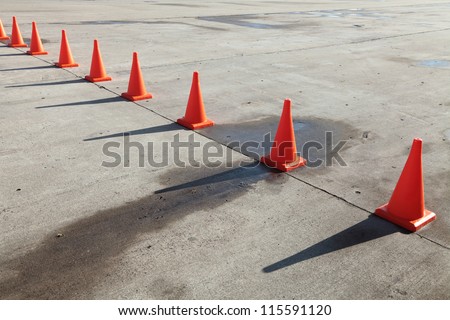 A row of orange traffic cones set on the road