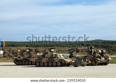 Engineering military vehicles at the firing range - bridgelayer, demining machine and the machine mouldboard