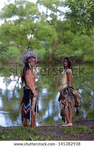 Indian chief with a young Indian on the banks of the river
