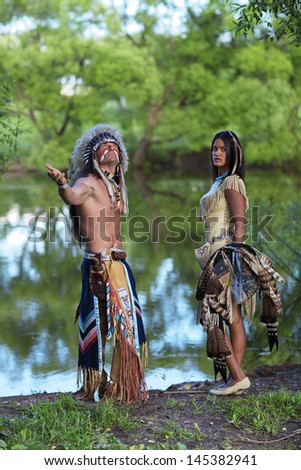 Indian chief with a young Indian on the banks of the river