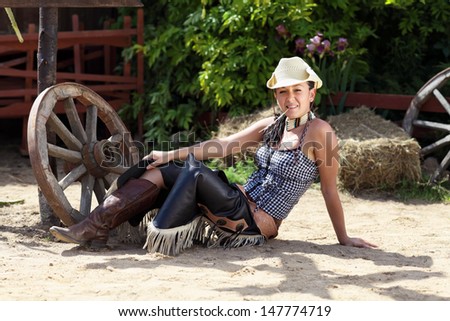The girl in cowboy clothes posing on a ranch