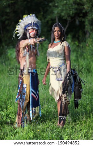 Indian chief with a young Indian on the green meadow