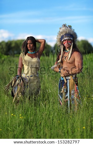 Indian chief with a young Indian standing in a green meadow