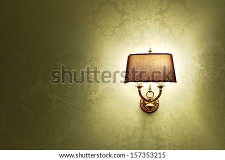 Wall lamp with a shade on the background of Golden Wallpaper