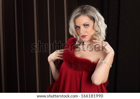 Portrait of a girl in a red fur dress on a dark background
