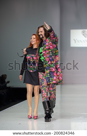 MOSCOW, RUSSIA - APR 1, 2014: Moscow Fashion Week. Cult media icon Nikita Dzhigurda with his wife ice dancer Marina Anissina takes part in fashion show the collection of clothing designer YanaStasia