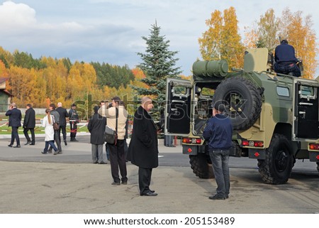 NIZHNY TAGIL, RUSSIA - SEP 26, 2013: The international exhibition of armament, military equipment and ammunition RUSSIA ARMS EXPO. Visitors examine a multipurpose infantry mobility vehicle GAZ Tigr