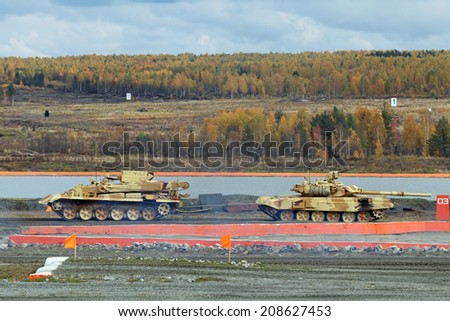 NIZHNY TAGIL, RUSSIA - SEP 26, 2013: The international exhibition of armament, military equipment and ammunition RUSSIA ARMS EXPO (RAE-2013). The towing tank T-72 by armour recovery vehicle BREM-1
