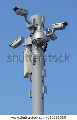 Five outdoors cameras surveillance and control on the background of blue sky
