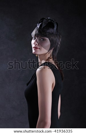 Portrait of the beautiful girl against a dark gray wall