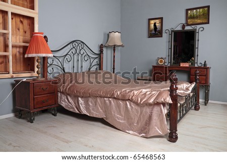 Bedroom with gray to walls, a double iron bed, a bedside table of a pier glass and night lamps
