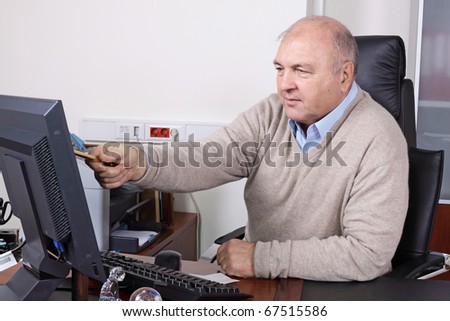 The elderly man at the computer at office