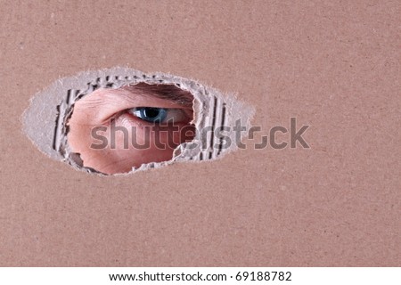 The man spies through a hole in a cardboard box