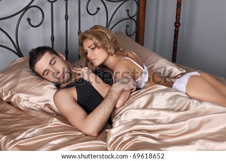 The girl and the guy in a bed. The girl wants sexual relations, but the guy has fallen asleep