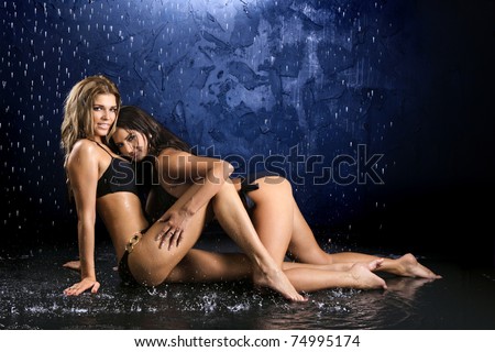 stock photo : Two sexy girls in bathing suits embrace in water splashes