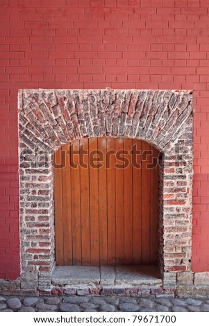 Detail of architecture, colorful brick arch in the background red brick walls