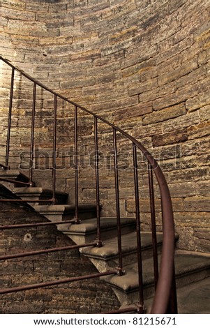 Dark stone spiral staircase with railings