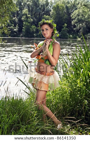 Portrait of a young girl on the bank of the river, dressed up for the holiday of Ivan Kupala (John Baptist\'s Day)