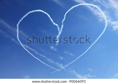 Two of the plane in the blue sky show figures of aerobatics - smoke painted heart