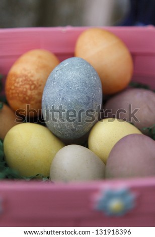 Easter eggs dyed with colors derived from plants, in a pink basket