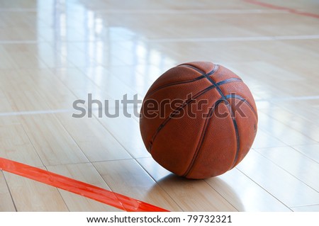 Basketball over wooden floor. Close up.