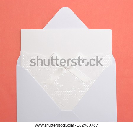 Wedding invitation in the envelope on a red background.