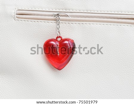 Charm in the form of the heart, hanging down from a pocket