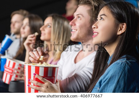 Bon appetit! Closeup shot of a young woman feeding her cheerful laughing man with popcorn at the movie theater