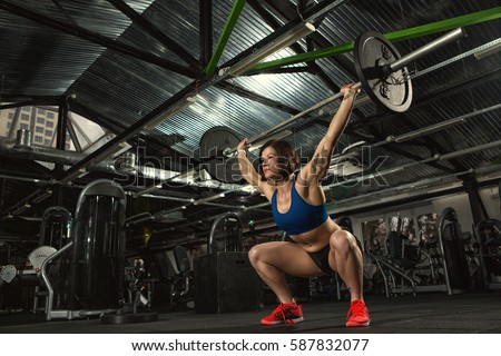 Focused on success. Low angle shot of an attractive strong muscular female bodybuilder doing heavy duty squats lifting barbell at the gym copyspace motivation crossfit fitness sport activity training