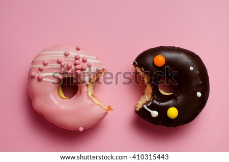 Donuts with icing on pink background. Sweet donuts. Donuts background . Eaten donut.