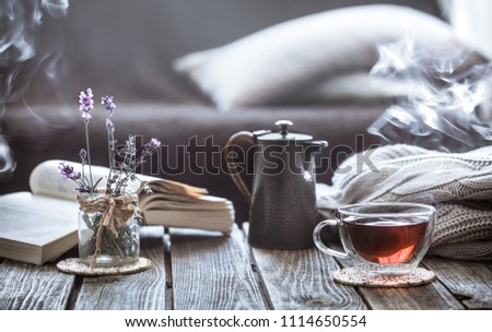 still life tea drinking in the living room a cup of tea with a kettle and a book on a wooden table, the concept of coziness