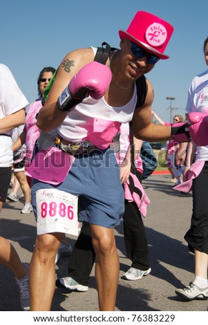 FORT WORTH - APRIL 9: An unidentified runner in the Fort Worth Susan G. Koman Race for the Cure takes up a fighting stance for the camera in Fort Worth, Texas on April 9, 2011.