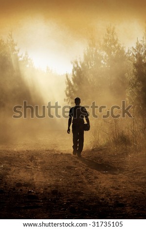 Man walking down gravel road after a forest fire