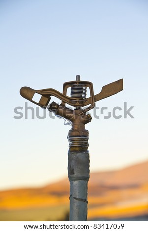 Irrigation head covered in ice with blurred background