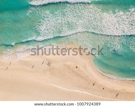 Top view of beautiful beach. Aerial drone shot of turquoise sea water at the beach - space for text. Caribbean seaside beach with turquoise water and big waves aerial view. Cancun beach aerial view.