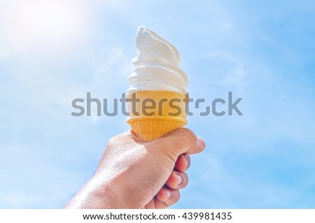 Soft white milk cream ice cream cone serve in hot summer day on sky background with sun lighting