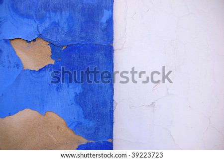 Blue and white wall in a mediterranean country with cracked paint