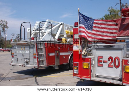 The back of two fire trucks with the American flag flying against one. Taken shortly after Katrina in Slidell, LA