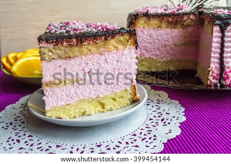 Biscuit cake with fruit souffle, decorated with chocolate and cup of tea. Piece of Cake is insulated.