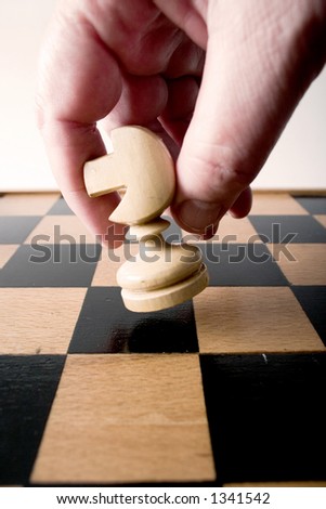 hand moving chess figure over chess board