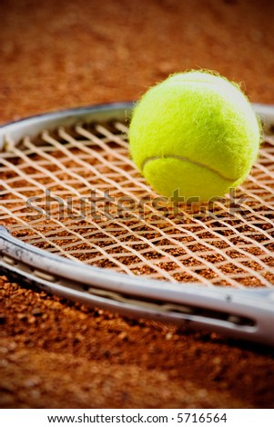 Tennis racket with ball  on it clay on clay court