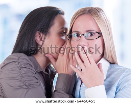 Office gossip concept. Two young girls whispering. Hi-res files, work path included