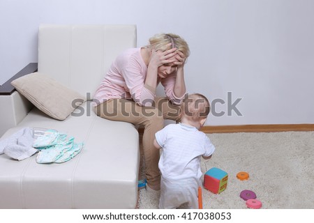 woman sits with her child, postpartum depression