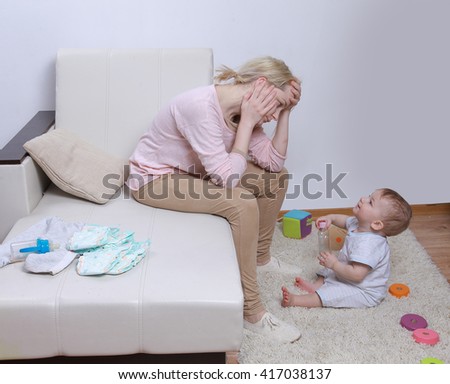 woman sits with her child, postpartum depression