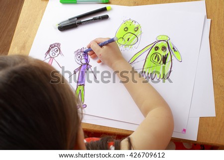 Girl in red dress draws a picture of the family. children\'s fears, bad dreams, nightmares.