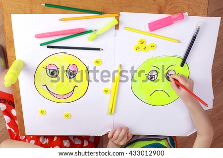 the development of emotional intelligence. child psychology. the girl and the boy draw happy and sad emoticons