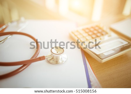 Health care costs concept picture : Selective focus Stethoscope and calculator on a medical chart ,symbol for health care costs or medical insurance with effect light added.