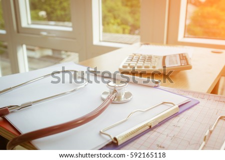 Health care costs concept picture : Stethoscope and calculator on a medical chart ,symbol for health care costs or medical insurance.